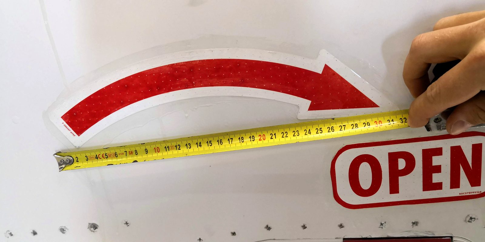 Curved door marking on a Boeing 737 being measured with a tape measure